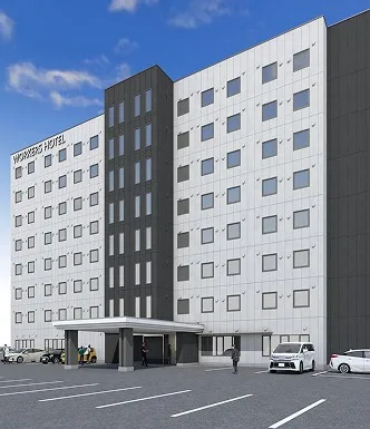 WORKERS HOTEL北九州若松の建物全景。白い外壁にダークグレーのアクセントが映える、広い駐車場を備えた開放的な佇まい。