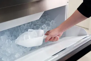 専用の白いスコップで製氷機から氷を取り出す様子