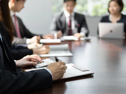 ホテル内の会議室で打ち合わせをするビジネスパーソンの手元