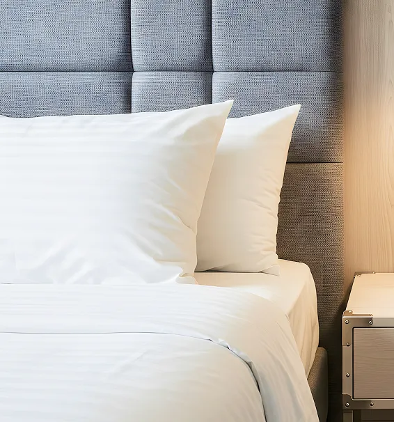 ホテルの客室にある清潔な白いベッドと枕