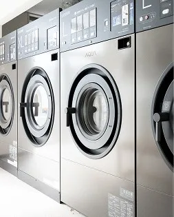 コインランドリーに並ぶ、シルバーの金属質な質感が特徴的な大型の業務用洗濯機。