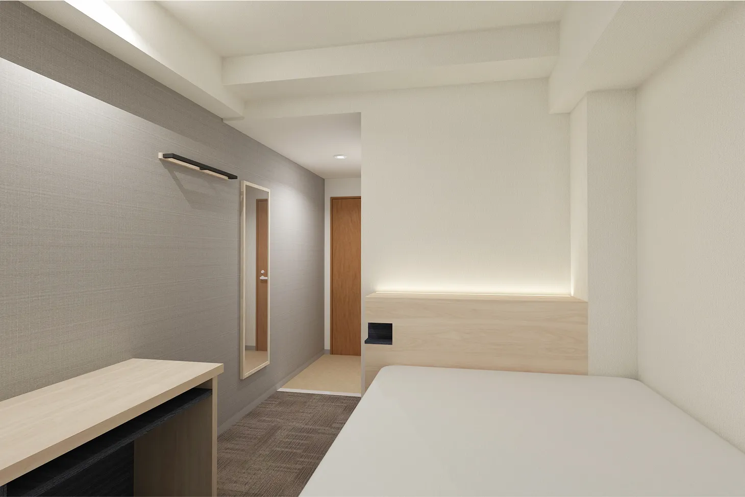 現代的でシンプル、明るい色調でまとめられたホテルの客室の、ベッド側から入口方向を写した写真。部屋の奥には木目調のドアがあり、手前右側にはヘッドボードと一体化した照明のある白いベッドが配置され、左側の壁には姿見と細長いデスクがある。