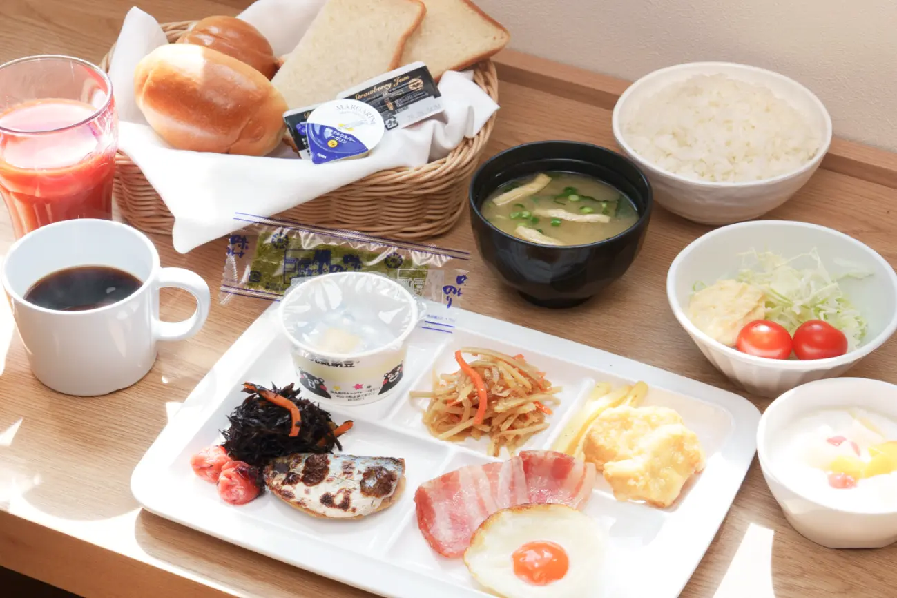 パンやご飯、焼き魚、目玉焼きなどが並ぶバランスの取れた和洋朝食セット